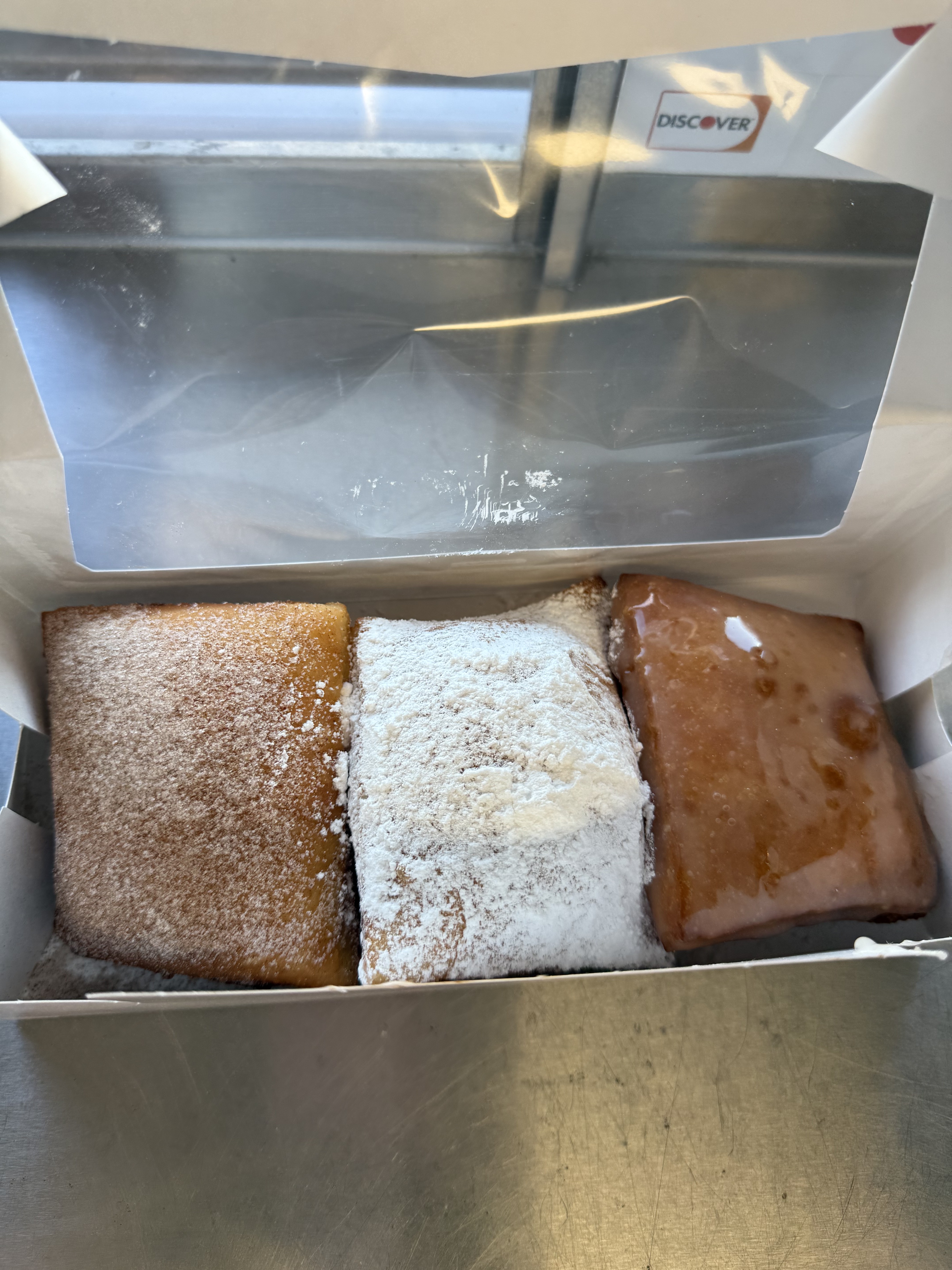 A mixed box of cinnamon sugar, powdered sugar, and glazed beignets
