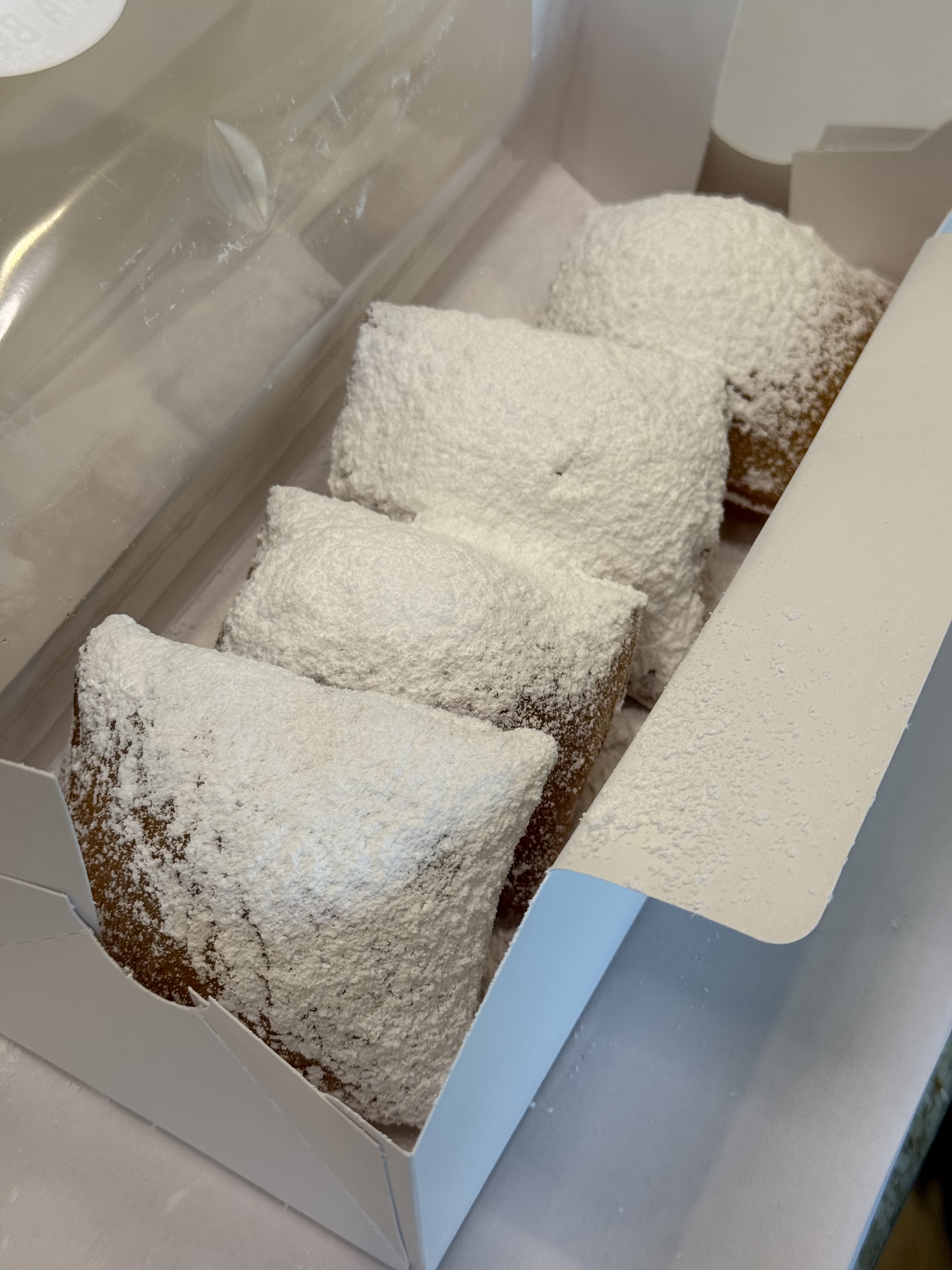 Powdered Sugar beignets in an open pastry box