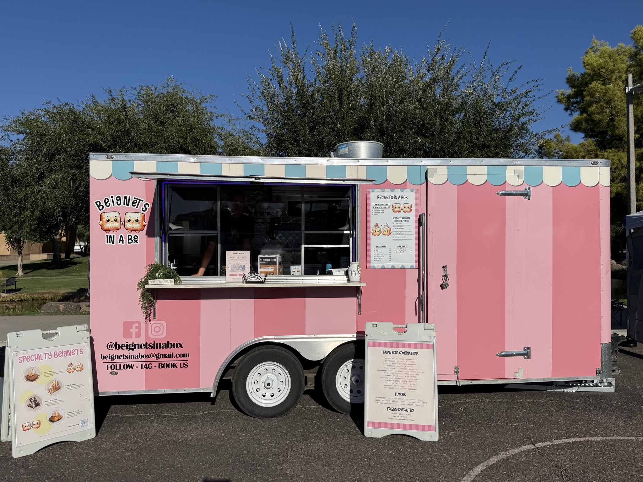 The pink Beignets in a Box trailer with its serving window open